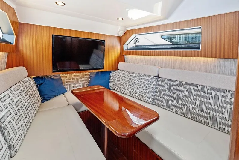 No Vacancy Yacht Photos Pics Luxurious interior of 2022 Pursuit S 428 Sport boat with elegant seating and TV.
