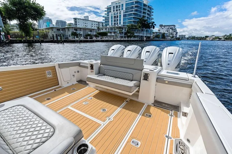 No Vacancy Yacht Photos Pics 2022 Pursuit S 428 Sport boat with luxurious seating and powerful engines on a scenic waterfront.