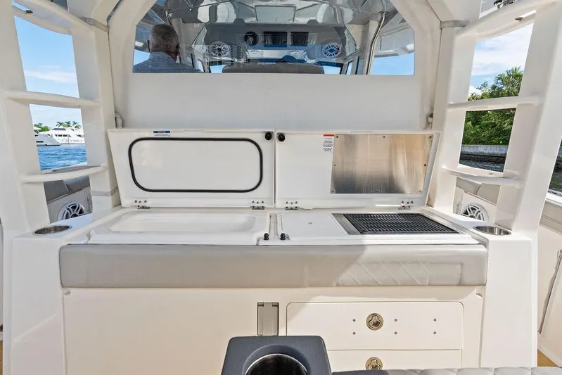 No Vacancy Yacht Photos Pics 2022 Pursuit S 428 Sport boat interior with grill and storage compartments.