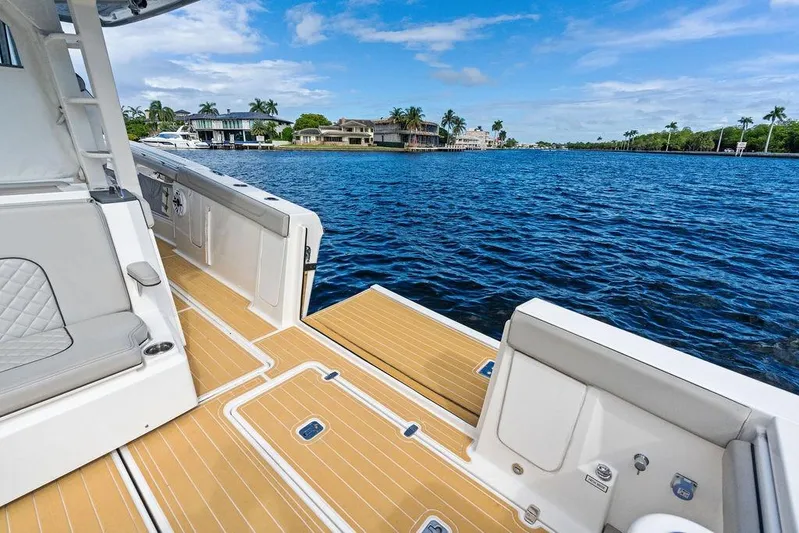 No Vacancy Yacht Photos Pics 2022 Pursuit S 428 Sport boat with luxurious deck, overlooking serene waterfront homes.