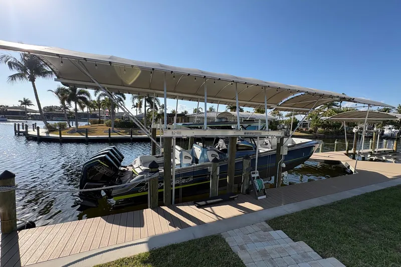  Yacht Photos Pics 2023 Nor-Tech 390 Sport Center Console docked under canopy, surrounded by palm trees.