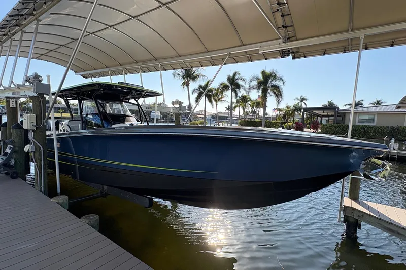  Yacht Photos Pics 2023 Nor-Tech 390 Sport Center Console boat docked under canopy with palm trees in background.