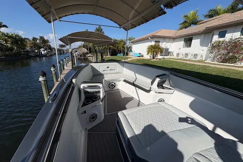  Yacht Photos Pics 2023 Nor-Tech 390 Sport Center Console boat docked by a canal, featuring luxurious seating.