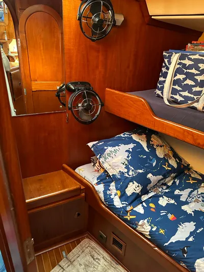 Sarama Yacht Photos Pics Cozy 1988 Ancosta Dubois boat cabin with nautical-themed bedding and wooden interior.