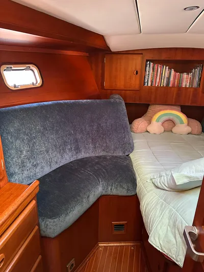 Sarama Yacht Photos Pics Cozy cabin interior of 1988 Custom Ancosta Dubois yacht with plush seating and bookshelf.