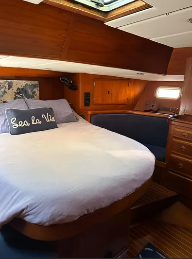 Sarama Yacht Photos Pics Cozy cabin interior of 1988 Custom Ancosta Dubois yacht with bed and wooden furnishings.