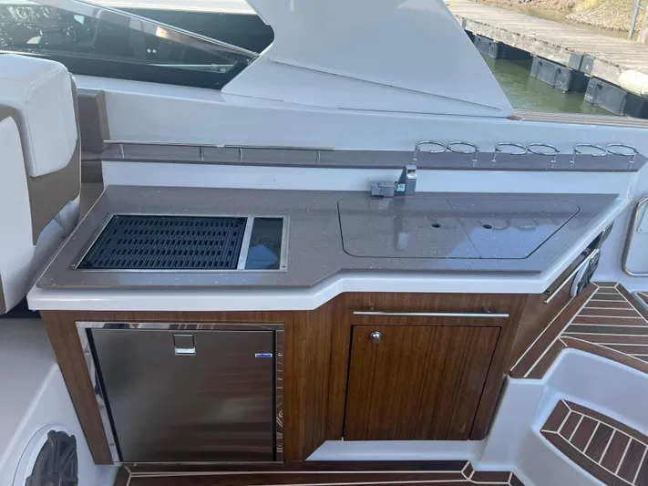  Yacht Photos Pics 2015 Four Winns H350 boat kitchenette with sink, grill, and storage cabinets.