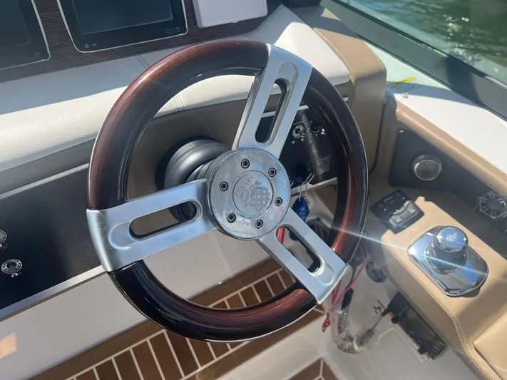 Yacht Photos Pics Steering wheel of a 2015 Four Winns H350 boat, featuring a sleek design.