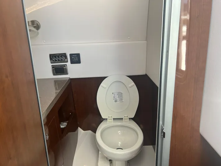  Yacht Photos Pics 2015 Four Winns H350 boat bathroom with toilet and wooden cabinetry.