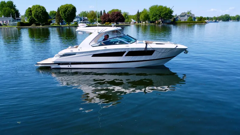  Yacht Photos Pics 2015 Four Winns H350 boat on calm lake with lush green shoreline.