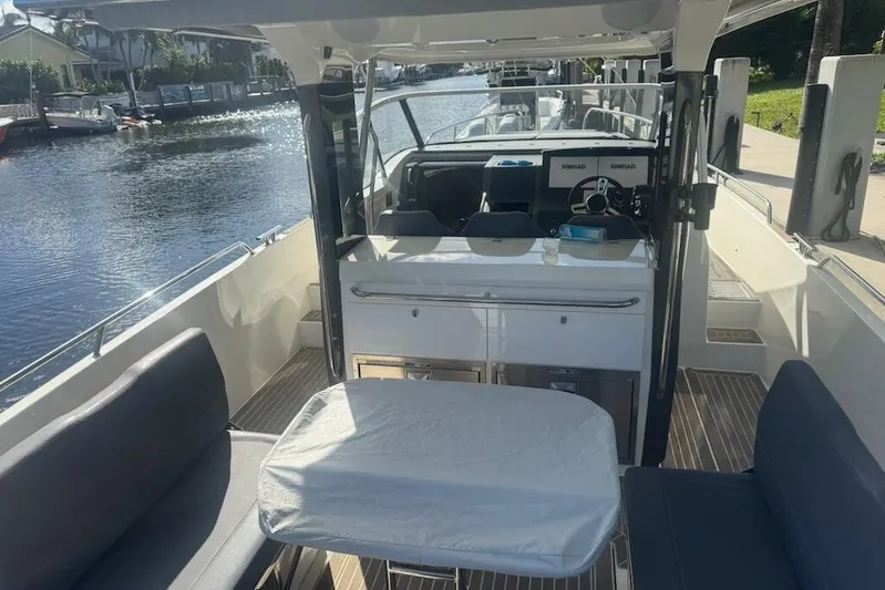 Nim2021xyz21 Yacht Photos Pics 2021 Nimbus T11 boat interior with seating and table on a sunny day.