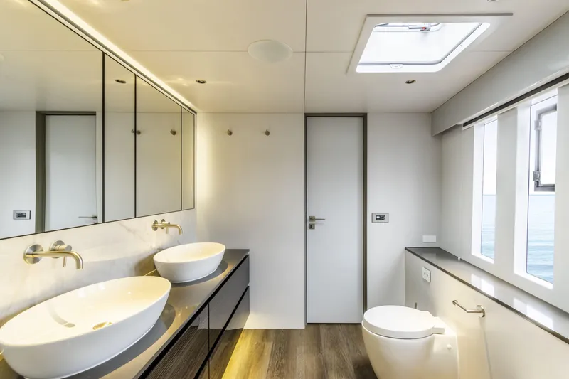 Naoma Yacht Photos Pics Luxurious bathroom on 2022 Sunreef 70 NAOMA yacht with dual sinks and ocean view.