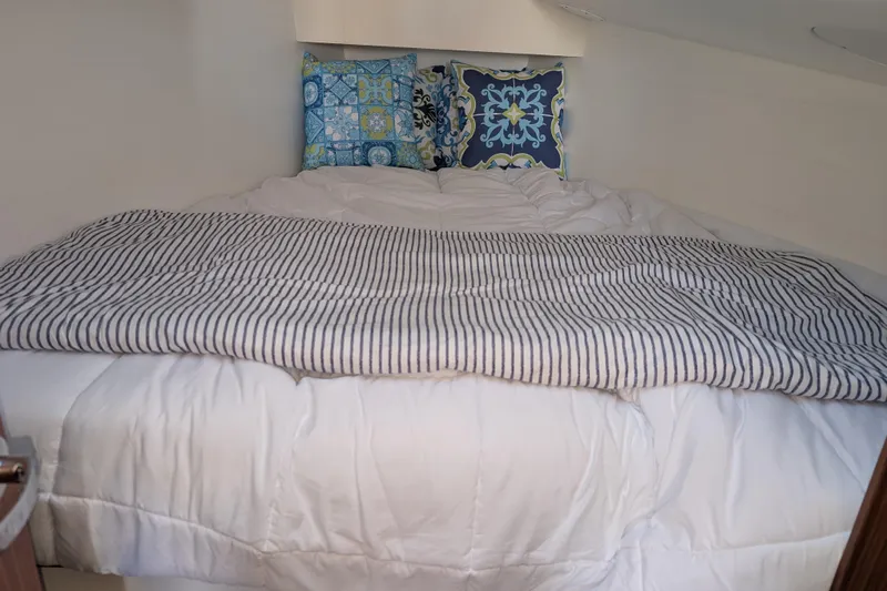Blue Yonder Yacht Photos Pics Cozy cabin bed in 2024 J Boats J/112E with decorative pillows and striped blanket.