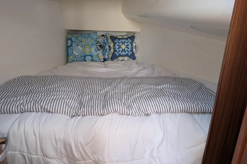 Blue Yonder Yacht Photos Pics Cozy cabin interior of 2024 J Boats J/112E with striped bedding and decorative pillows.