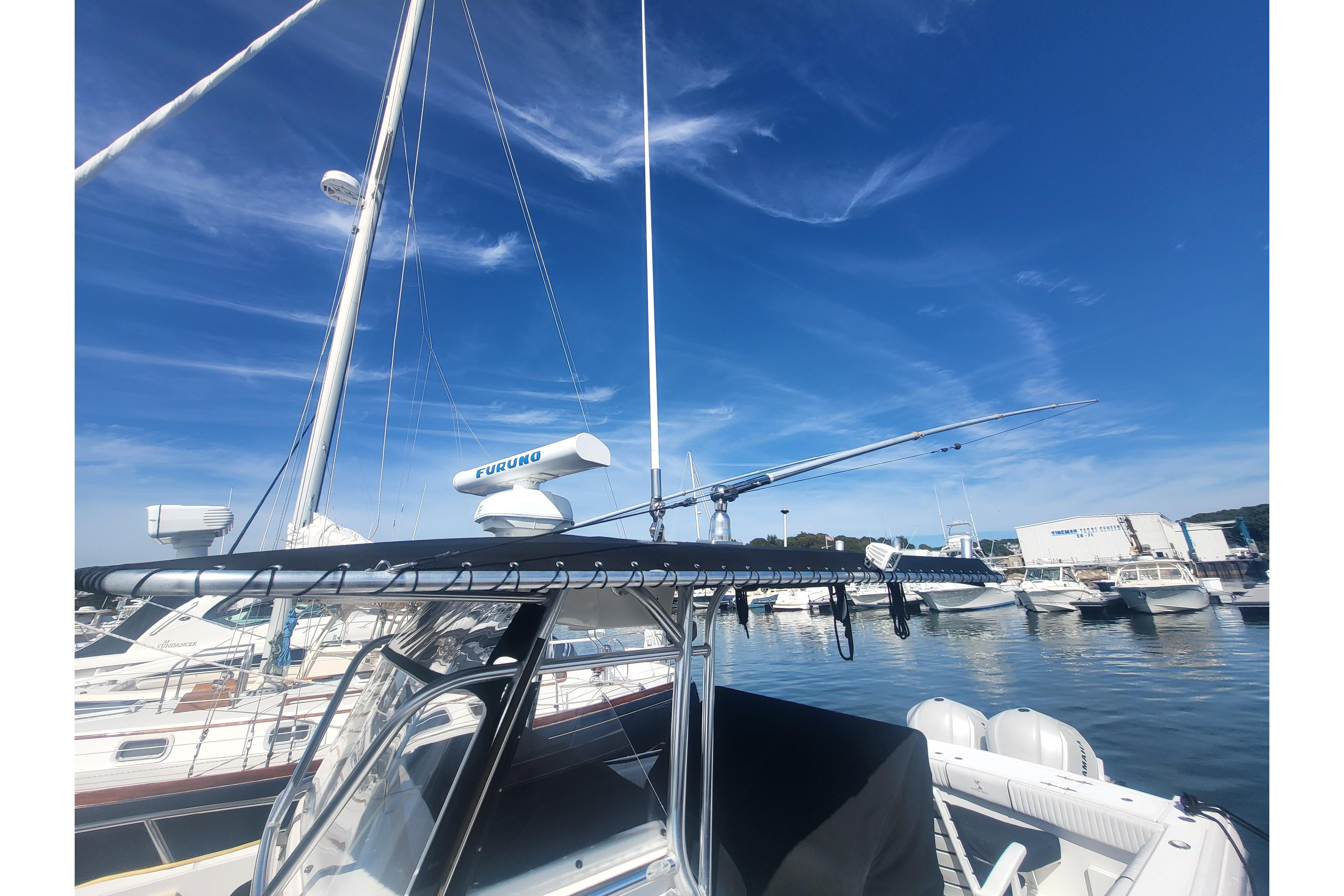 2005 Stamas 310 Tarpon boat docked at marina under clear blue sky.