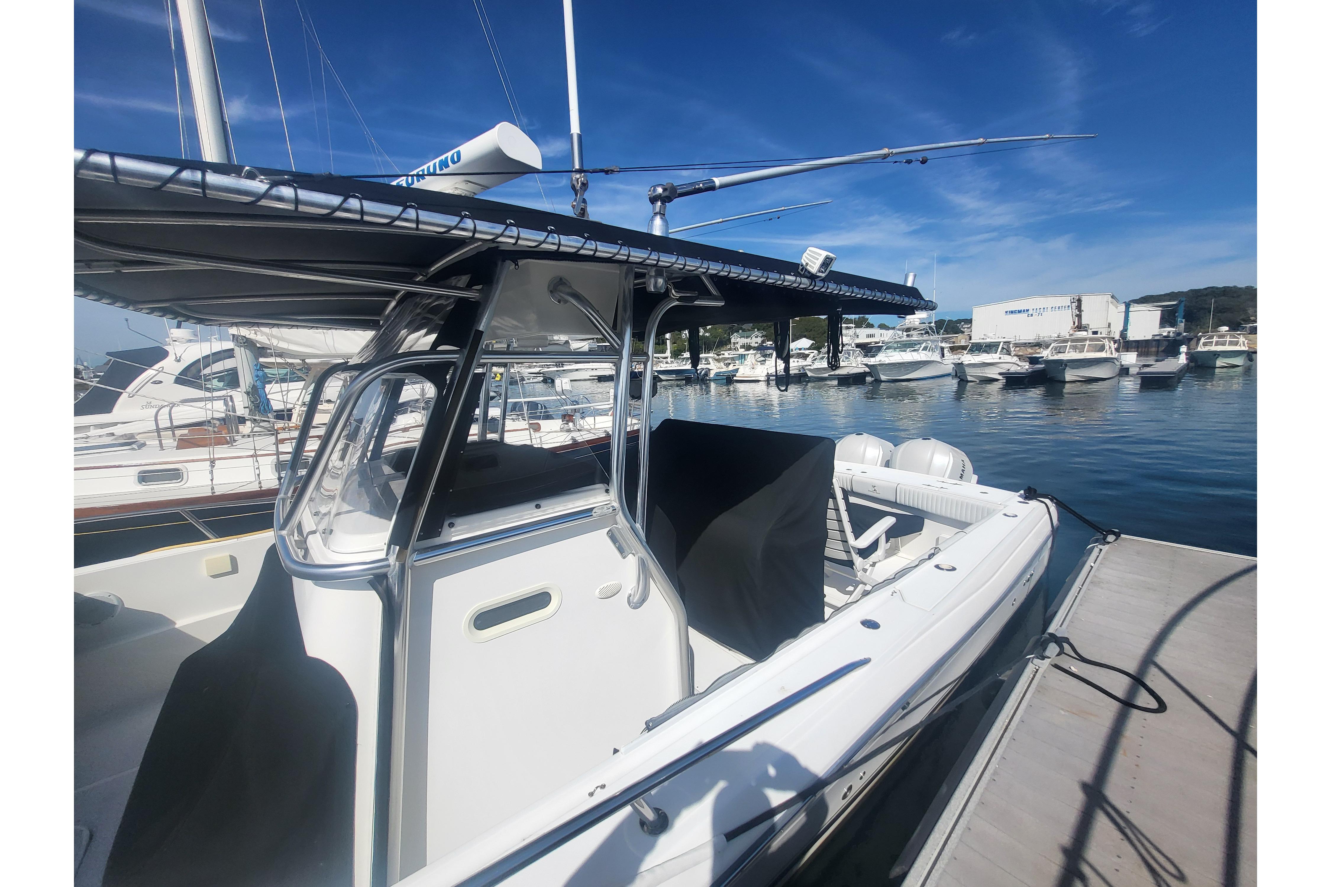 2005 Stamas 310 Tarpon boat docked at a marina under clear blue skies.