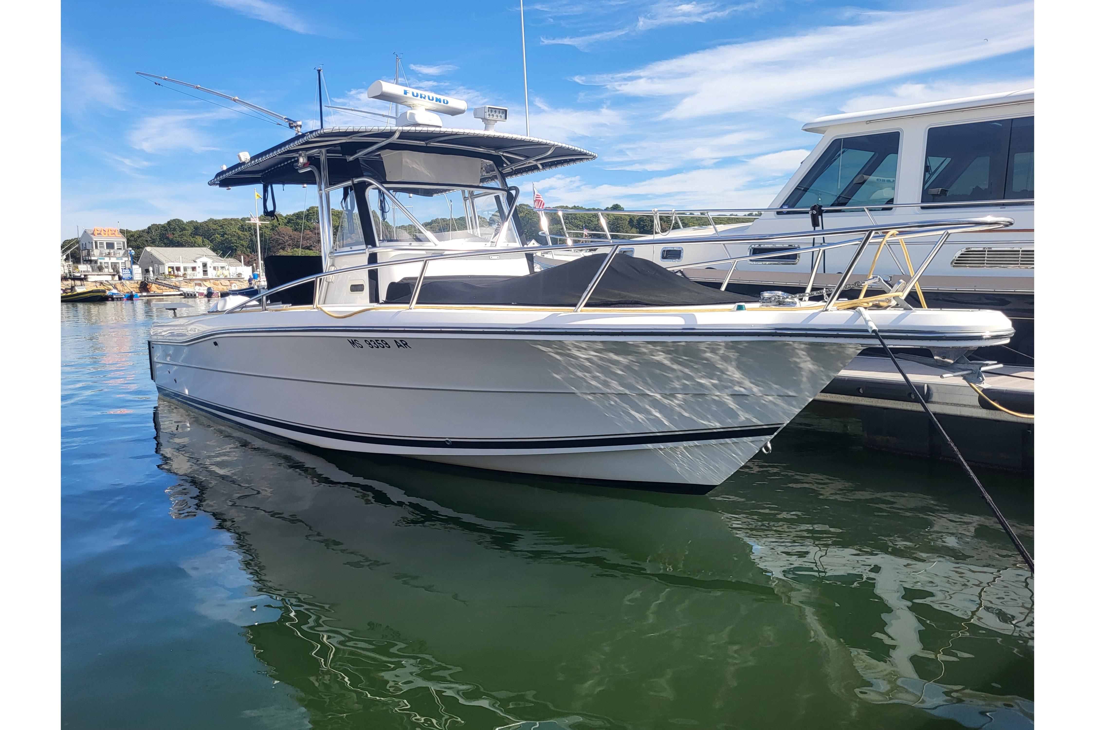 2005 Stamas 310 Tarpon boat docked in a marina under a clear blue sky.