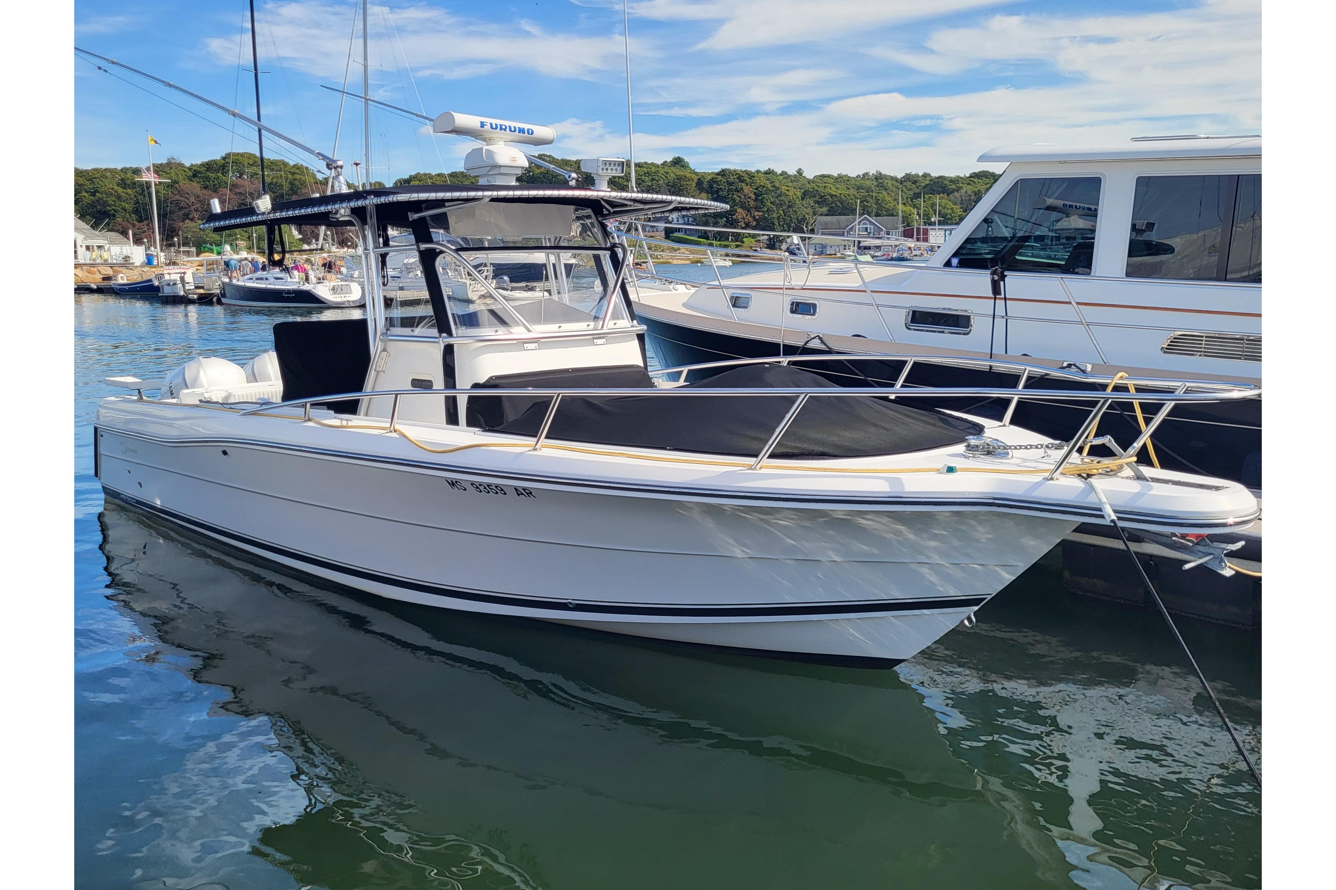 2005 Stamas 310 Tarpon boat docked in a marina, clear sky background.