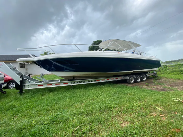  Yacht Photos Pics 2008 Intrepid 390 Sport Yacht on trailer, parked on grass under cloudy sky.
