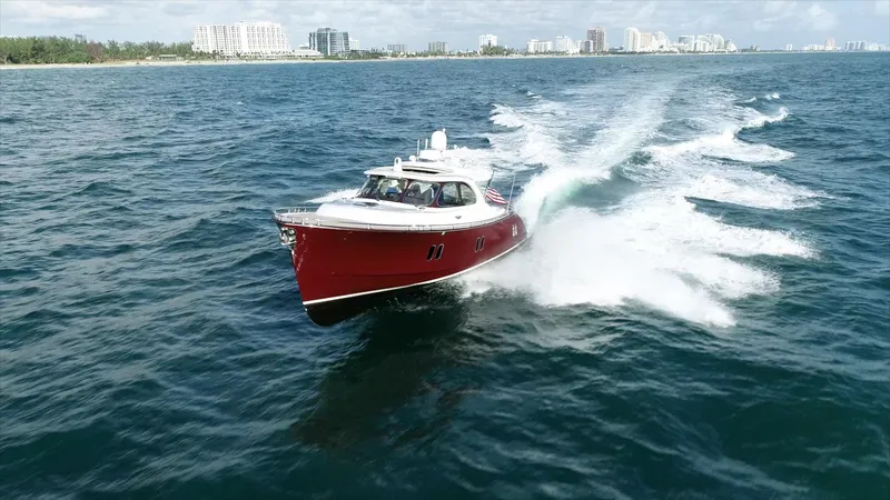 Gazelle Yacht Photos Pics Red 2014 Zeelander Z44 yacht cruising on open water near a city skyline.