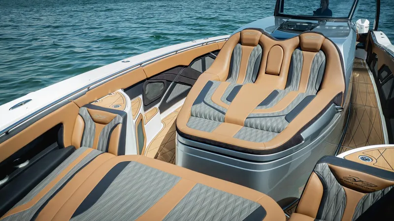  Yacht Photos Pics Luxurious 2022 MTI V50 boat interior with tan and gray seating on water.