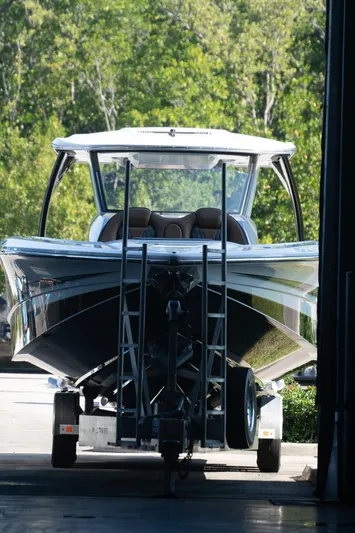  Yacht Photos Pics 2022 MTI V50 boat in storage, front view with lush greenery background.
