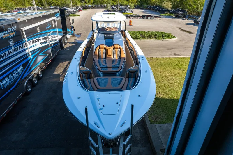  Yacht Photos Pics 2022 MTI V50 boat with sleek design and luxurious seating, parked outdoors.