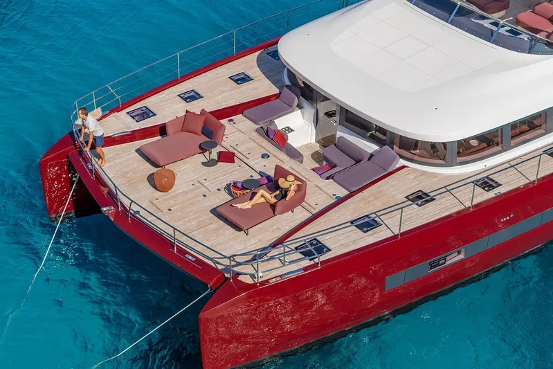  Yacht Photos Pics Manufacturer Provided Image: Luxurious 2026 Lagoon SIXTY 7 yacht with spacious deck, lounging area, and vibrant red hull.