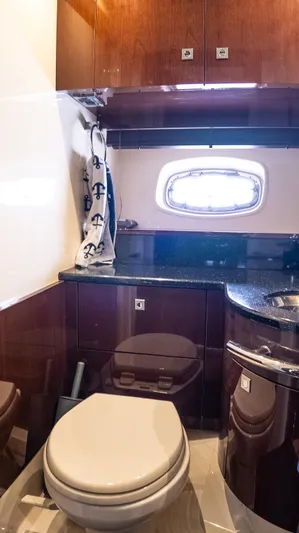 Jones'n Yacht Photos Pics 2009 Sea Ray 470 Sundancer yacht bathroom with wooden cabinets and porthole window.