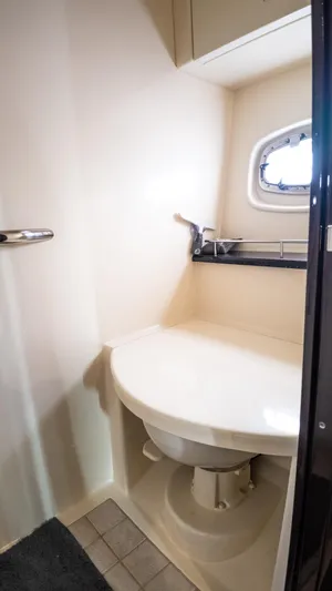 Jones'n Yacht Photos Pics Compact bathroom in 2009 Sea Ray 470 Sundancer yacht with porthole and sink.