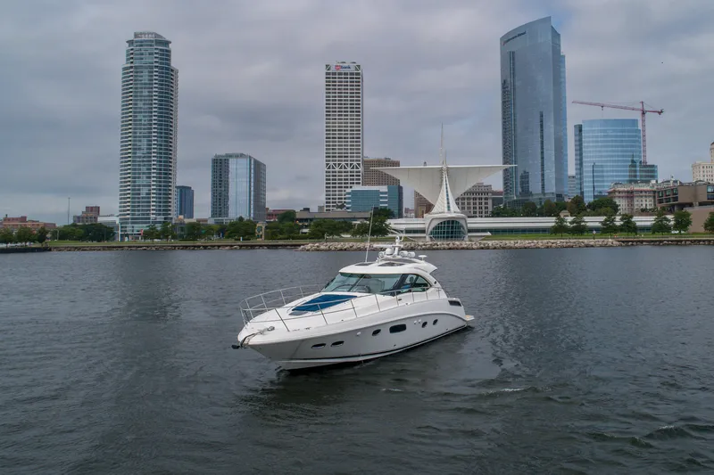Jones'n Yacht Photos Pics 2009 Sea Ray 470 Sundancer yacht cruising near city skyline and waterfront buildings.