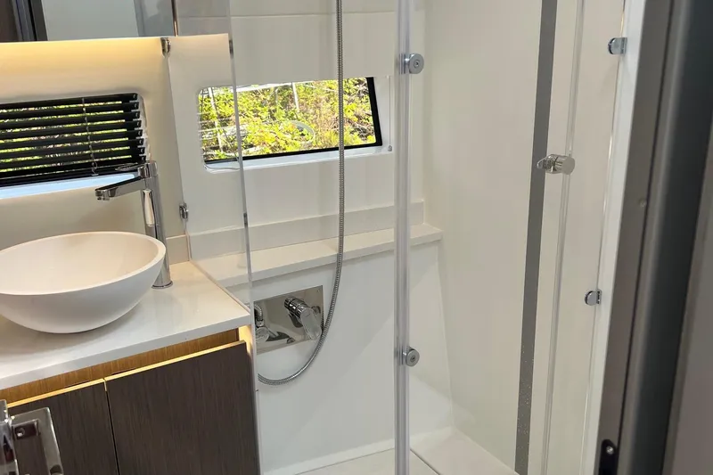  Yacht Photos Pics Modern bathroom interior of 2024 Jeanneau NC 1295 Fly yacht with sleek fixtures.