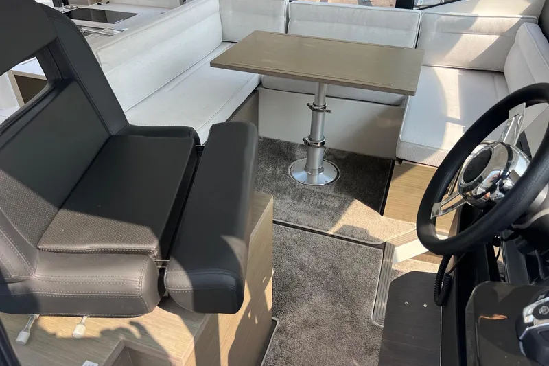  Yacht Photos Pics 2024 Jeanneau NC 1295 Fly interior with seating, table, and steering wheel.