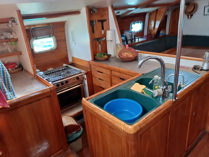 Atanahoue Yacht Photos Pics Cozy wooden kitchen interior on a 2000 Custom Paladin 60 boat, featuring a stove and sink.