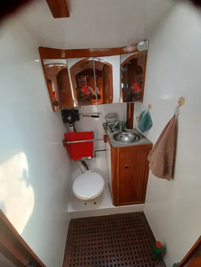Atanahoue Yacht Photos Pics Compact bathroom in a 2000 Custom Paladin 60 boat with wooden cabinetry and stainless steel sink.