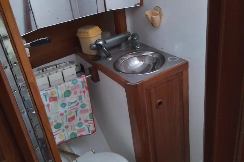 Atanahoue Yacht Photos Pics Small boat bathroom with sink, toilet, and wooden cabinetry in a Custom Paladin 60, 2000 model.