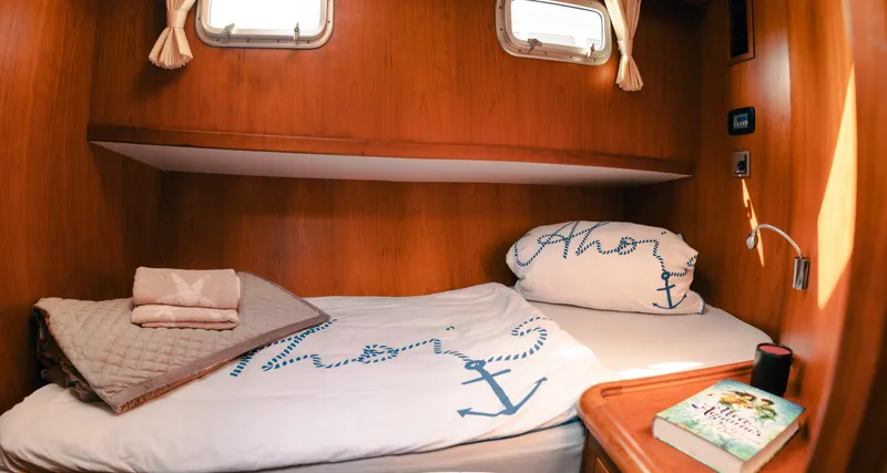  Yacht Photos Pics Cozy cabin interior of 2011 Privateer Trawler 50 with nautical-themed bedding.
