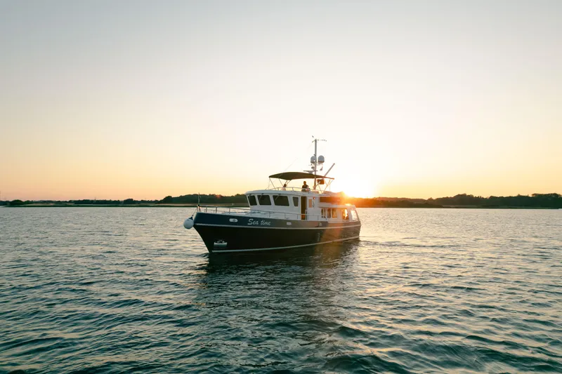  Yacht Photos Pics Privateer Trawler 50, 2011 model, cruising at sunset on calm waters.