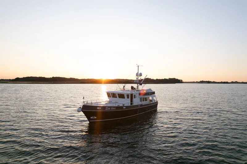  Yacht Photos Pics Privateer Trawler 50 (2011) cruising at sunset on calm waters.