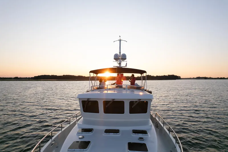  Yacht Photos Pics Privateer Trawler 50, 2011 model, cruising at sunset on calm waters.