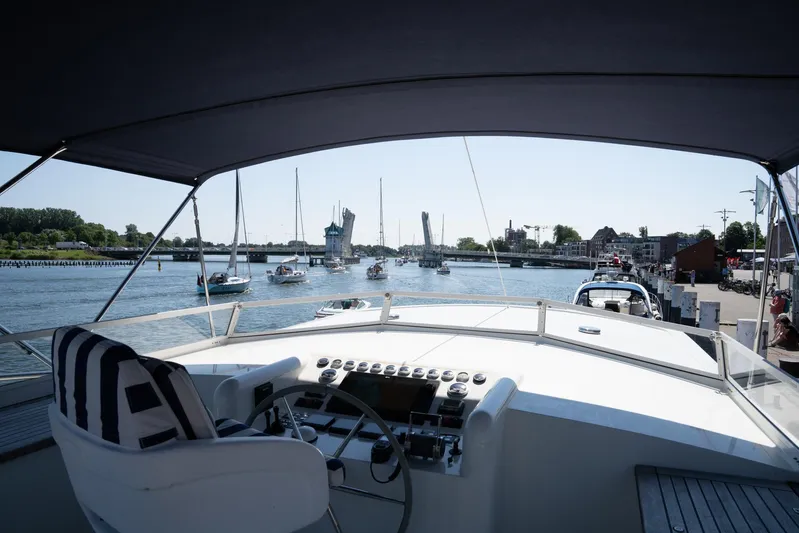  Yacht Photos Pics Helm view from 2011 Privateer Trawler 50, overlooking a marina with sailboats and a drawbridge.