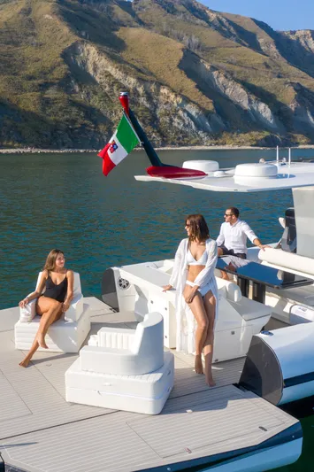  Yacht Photos Pics Luxury 2025 Anvera 42 yacht with people relaxing on deck, scenic mountain backdrop.