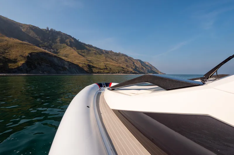  Yacht Photos Pics 2025 Anvera 42 yacht cruising near scenic coastal cliffs under clear blue skies.