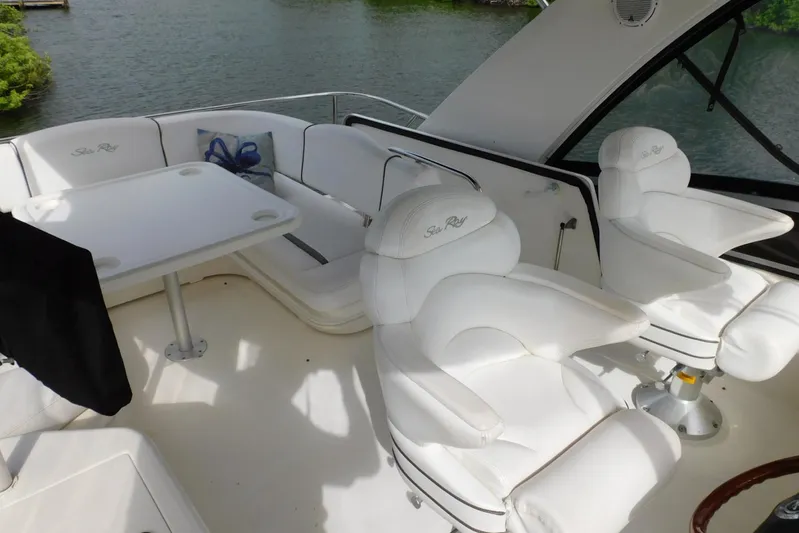 Full Deck Yacht Photos Pics 2008 Sea Ray 44 Sedan Bridge interior with white seating and table, overlooking water.