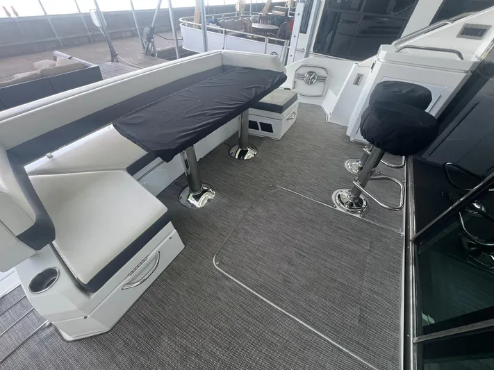 Mon Cheri Yacht Photos Pics 2018 Cruisers Yachts 54 Cantius cockpit with seating and bar stools, featuring modern design.