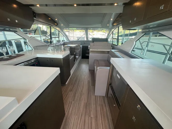 Mon Cheri Yacht Photos Pics Luxurious interior of 2018 Cruisers Yachts 54 Cantius with modern kitchen and seating area.