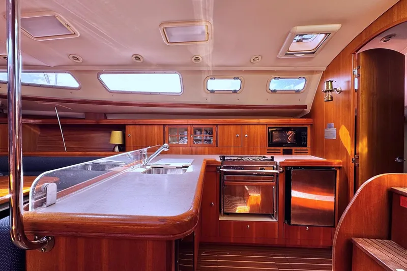  Yacht Photos Pics Interior of a 2006 Hunter 38 sailboat, featuring a modern kitchen and wooden cabinetry.