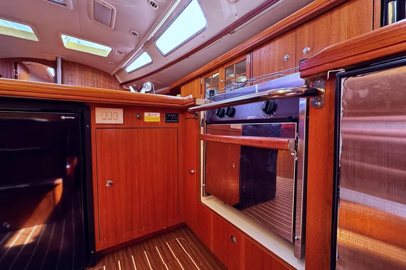  Yacht Photos Pics 2006 Hunter 38 yacht interior kitchen with wood cabinetry and modern appliances.