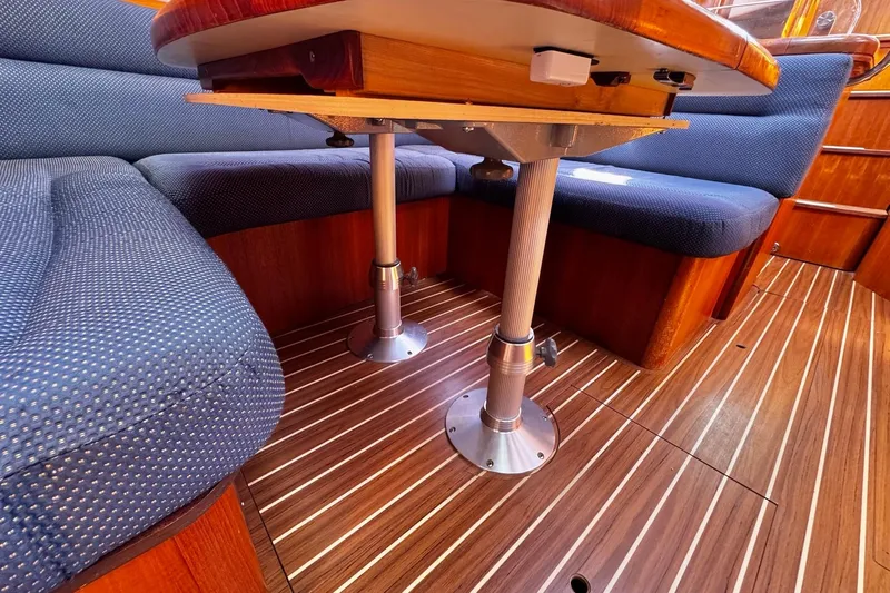  Yacht Photos Pics Interior of 2006 Hunter 38 sailboat with wooden flooring and blue cushioned seating.