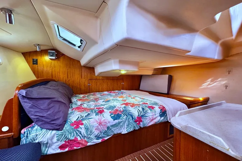  Yacht Photos Pics Cozy cabin interior of 2006 Hunter 38 sailboat with floral bedding and wood accents.